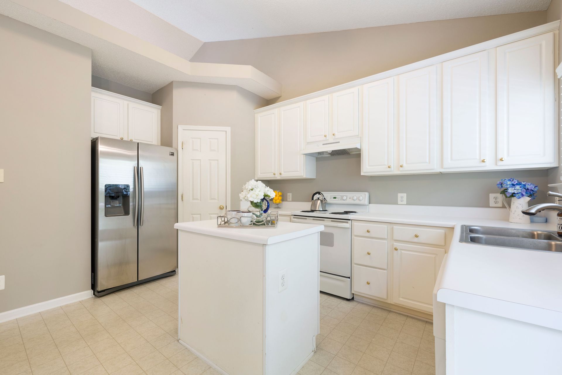 Modern kitchen with white cabinets and stainless steel appliances, perfect for contemporary homes.